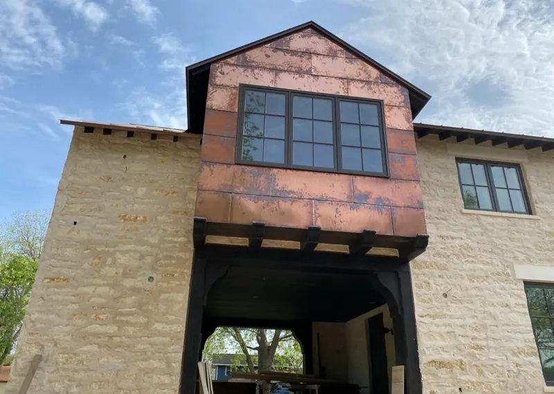 Copper metal panel facade on a stone building for Roof Repair in Apex